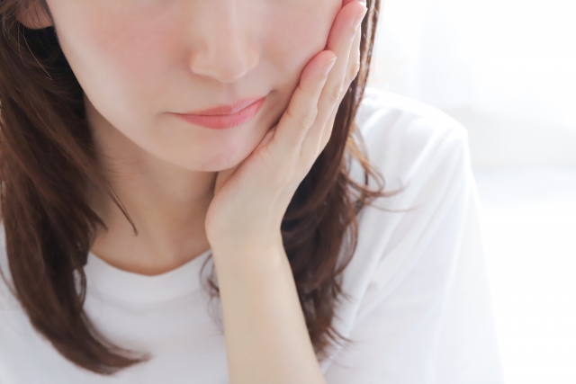 頬を抑える女性
